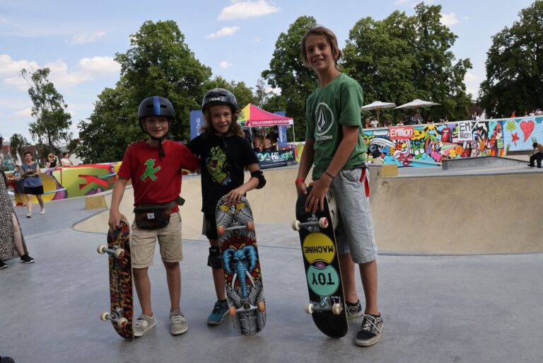 Zu sehen sind drei Jungs mit ihren bunten Skateboards