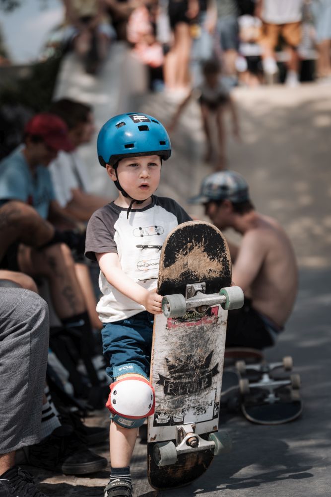 Ein Junge mit einem blauen Helm und einem Skateboard