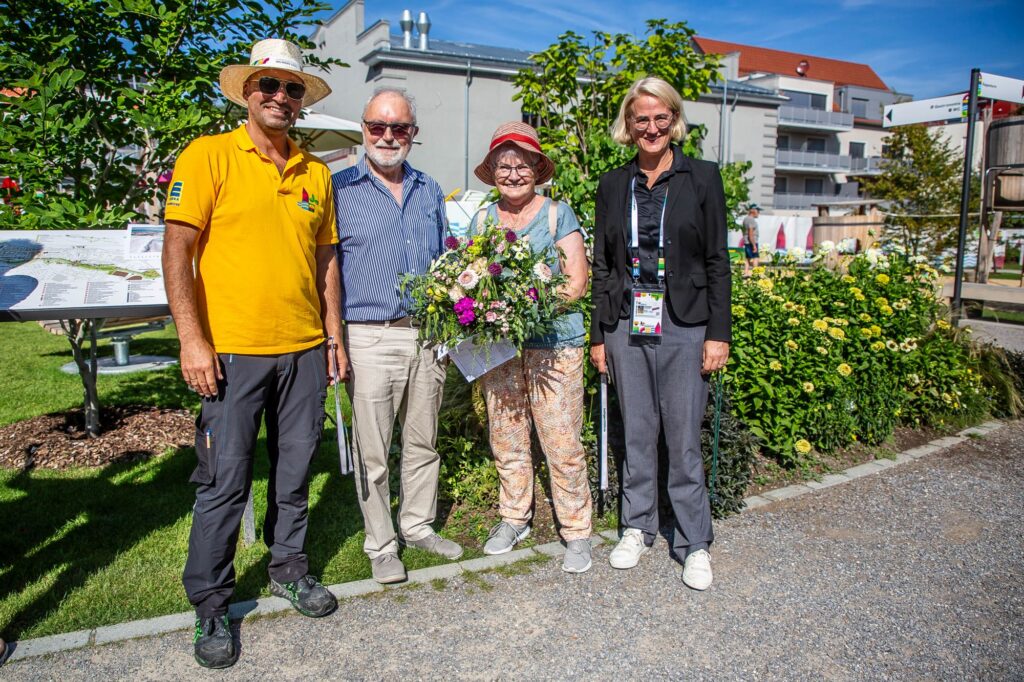 Zu sehen sind Niko Skarlatoudis und Annette Stoll-Zeitler von der Gartenschau mit den Meilensteinbesuchern Hubertus und Eva Kurz
