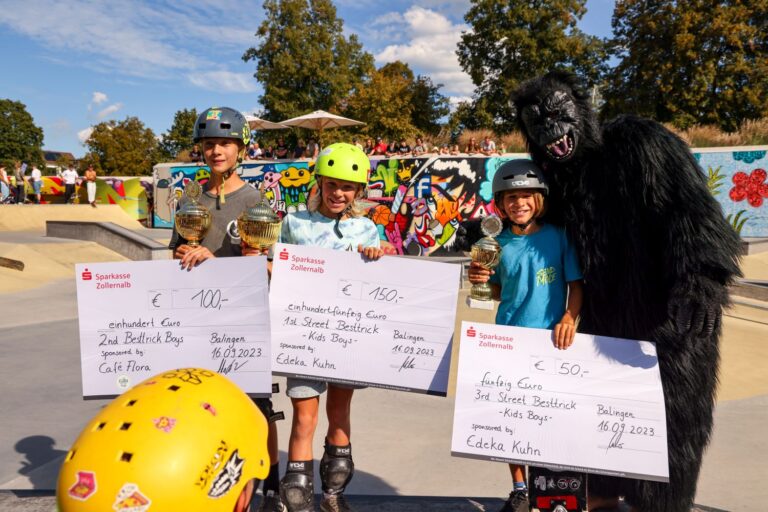 Die Siager der Kategorie "Kids Street Boys" mit ihren Pokalen und dem Preisgeld, daneben Maskottchen Gorilla Manny
